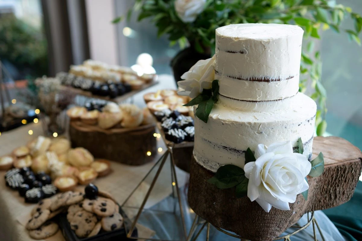 Hochzeitstorte, im Hintergrund ein Buffet mit Nachspeisen
